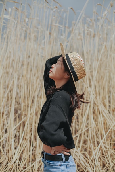 戴棕色草帽和黑色夹克的女人